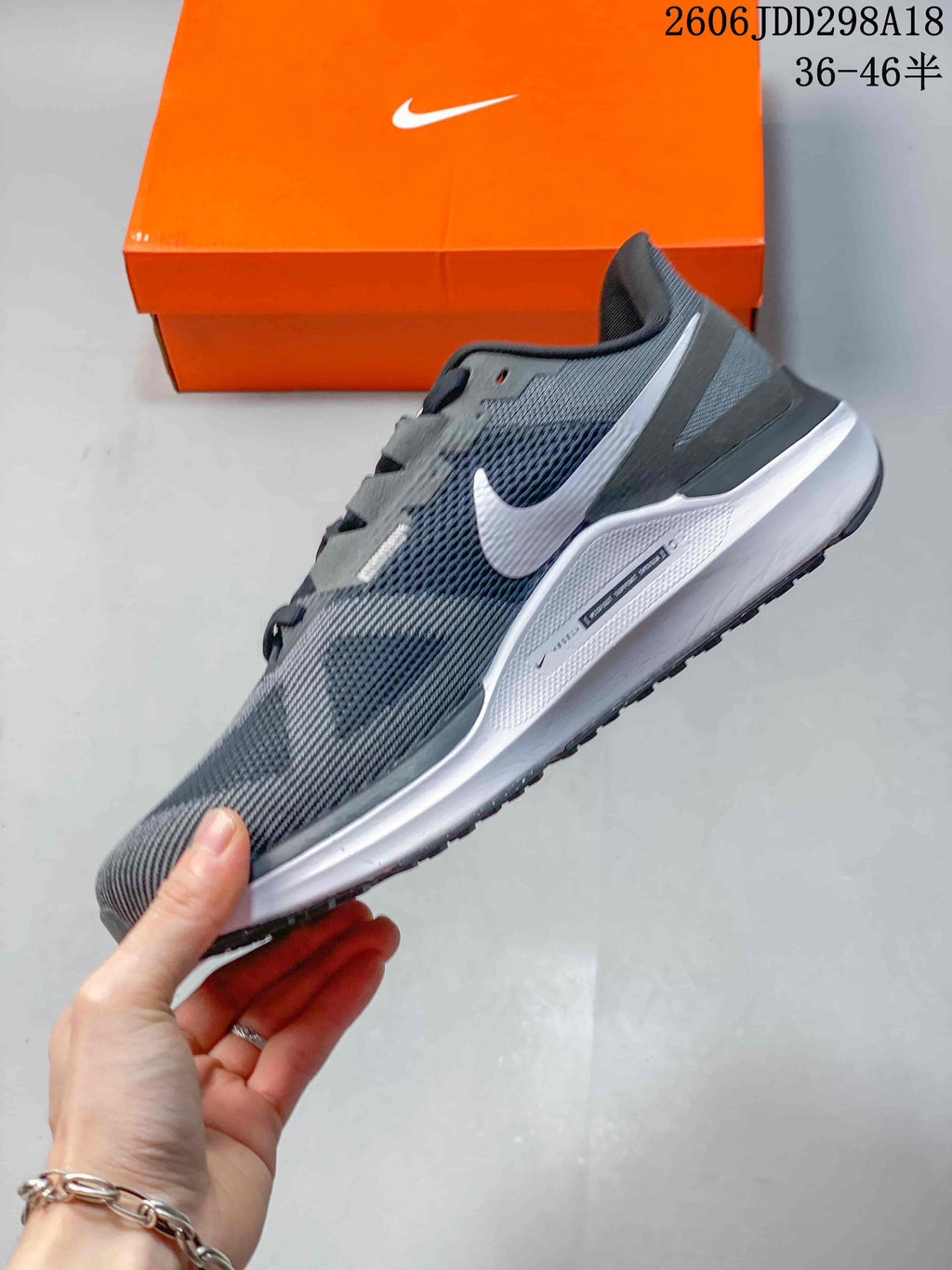 Side profile of a gray Nike running sneaker with white Swoosh branding, mesh upper, and white midsole.