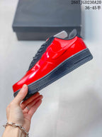 Side view of the sneaker showing the glossy red upper, black Swoosh, black midsole, and textured outsole.