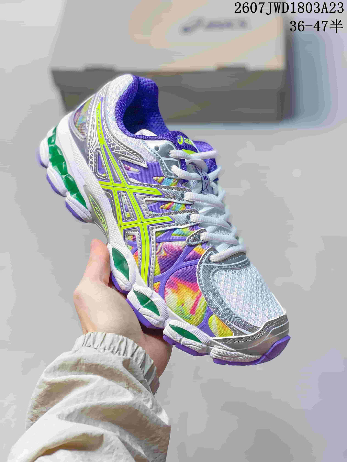 Angled side view of the ASICS Gel-Nimbus 16 sneaker showing the multicolor upper, lime branding, white midsole, and purple outsole.
