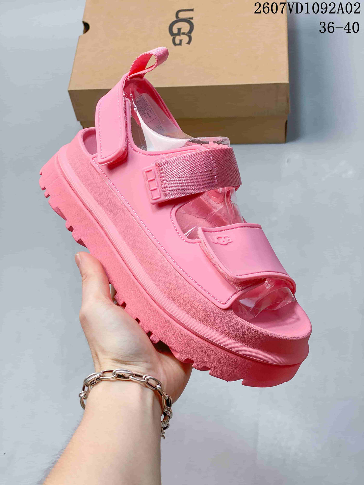 Pink platform sandal with adjustable straps and a heel strap, shown in side view.