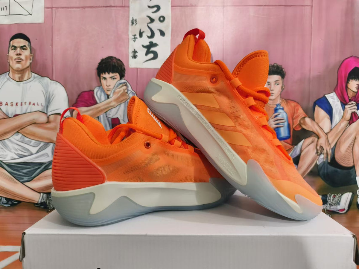 Pair of orange Nike basketball shoes shown from side and sole angles.