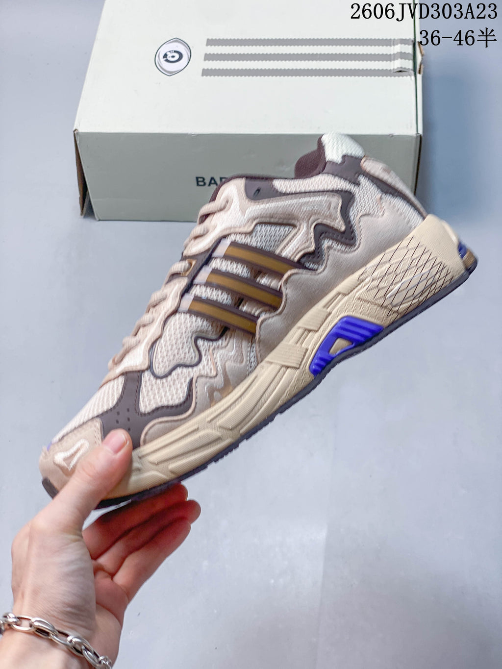 Side profile showing layered panels, three-stripe detailing and purple accents