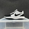 Side view of a white and black Nike low-top sneaker with white laces and a black Swoosh.