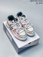 Pair of white and pale pink MLB sneakers with distressed graffiti graphics displayed on a branded shoe box.