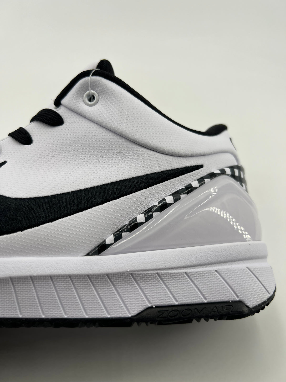 Close-up of the white side panel, black Swoosh, and heel structure