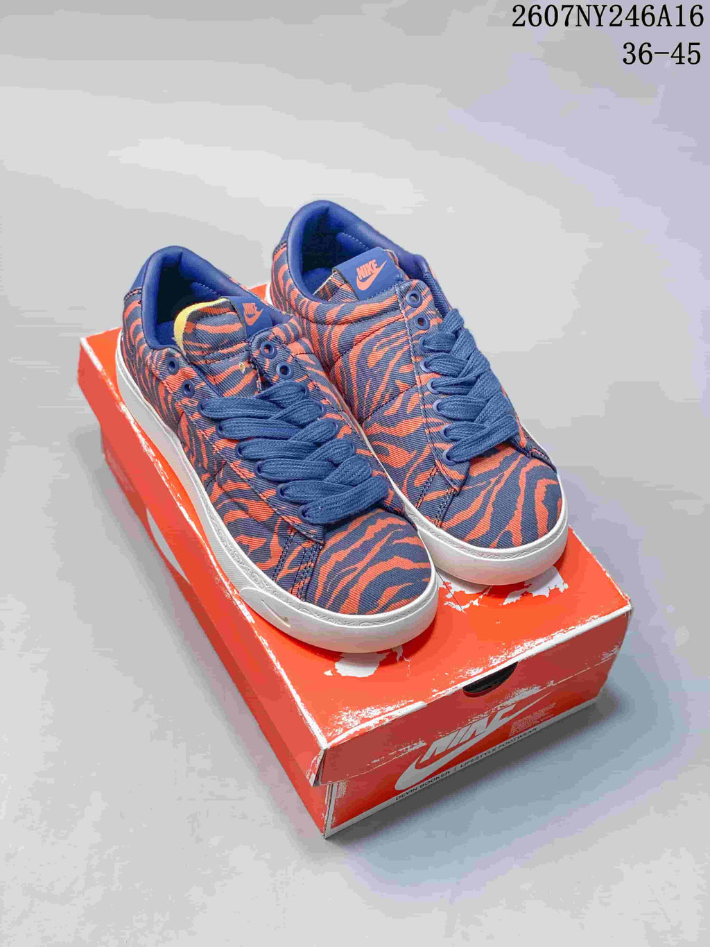 Pair of blue and orange tiger-stripe Nike low-top sneakers displayed on a Nike shoe box.
