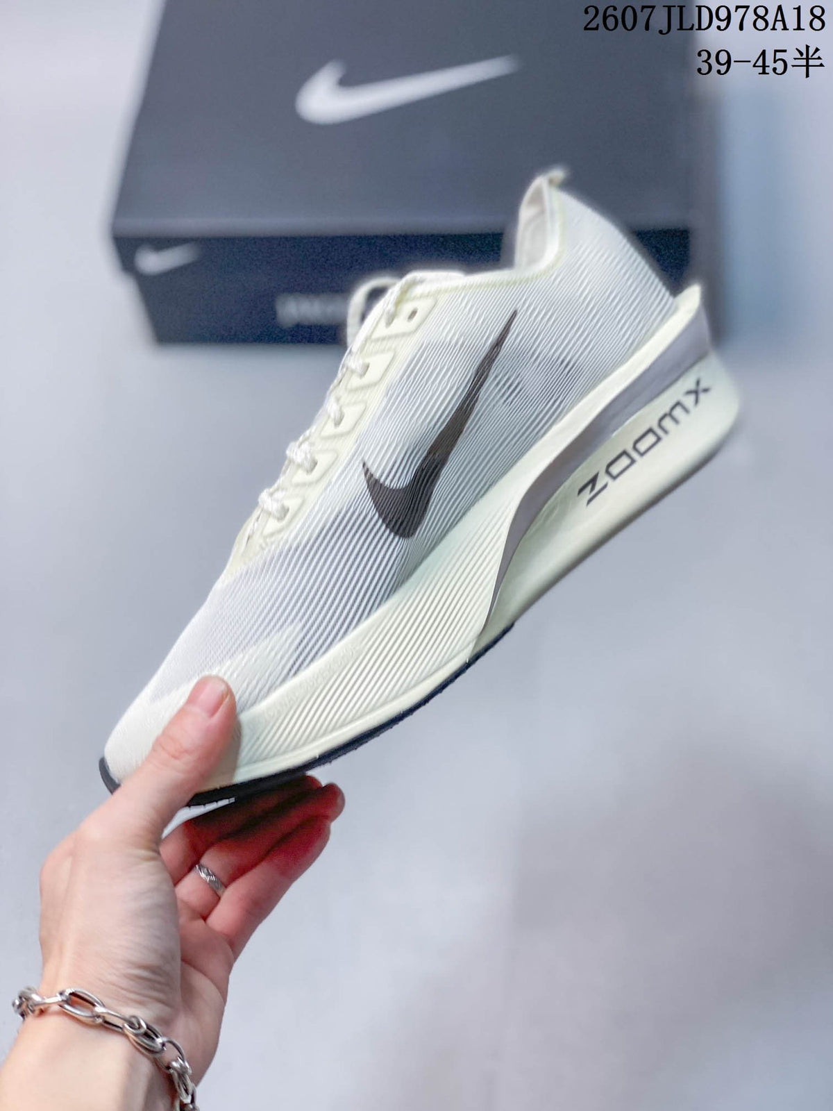 Side view of the white Nike Vaporfly shoe showing the dark Swoosh, raised midsole profile and ZoomX marking.