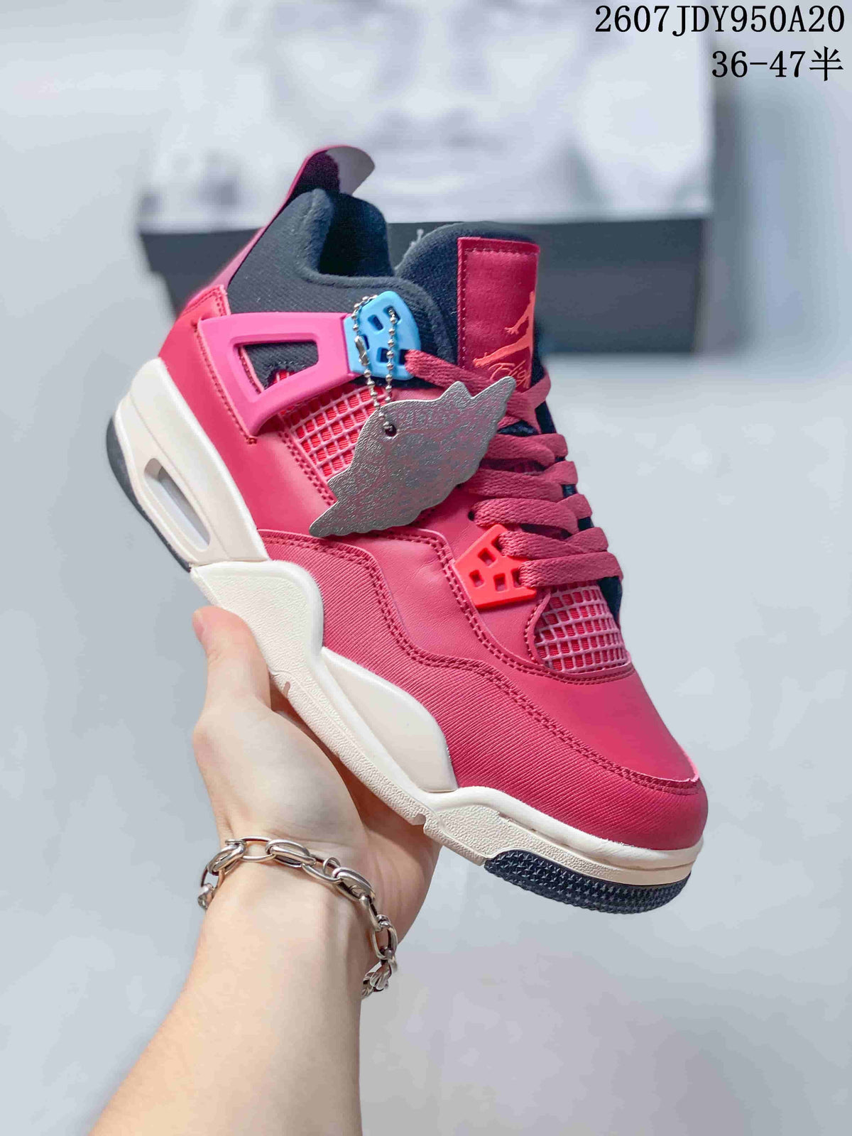 Angled side view showing the pink and black upper, blue and pink molded accents, white midsole, and decorative hangtag.