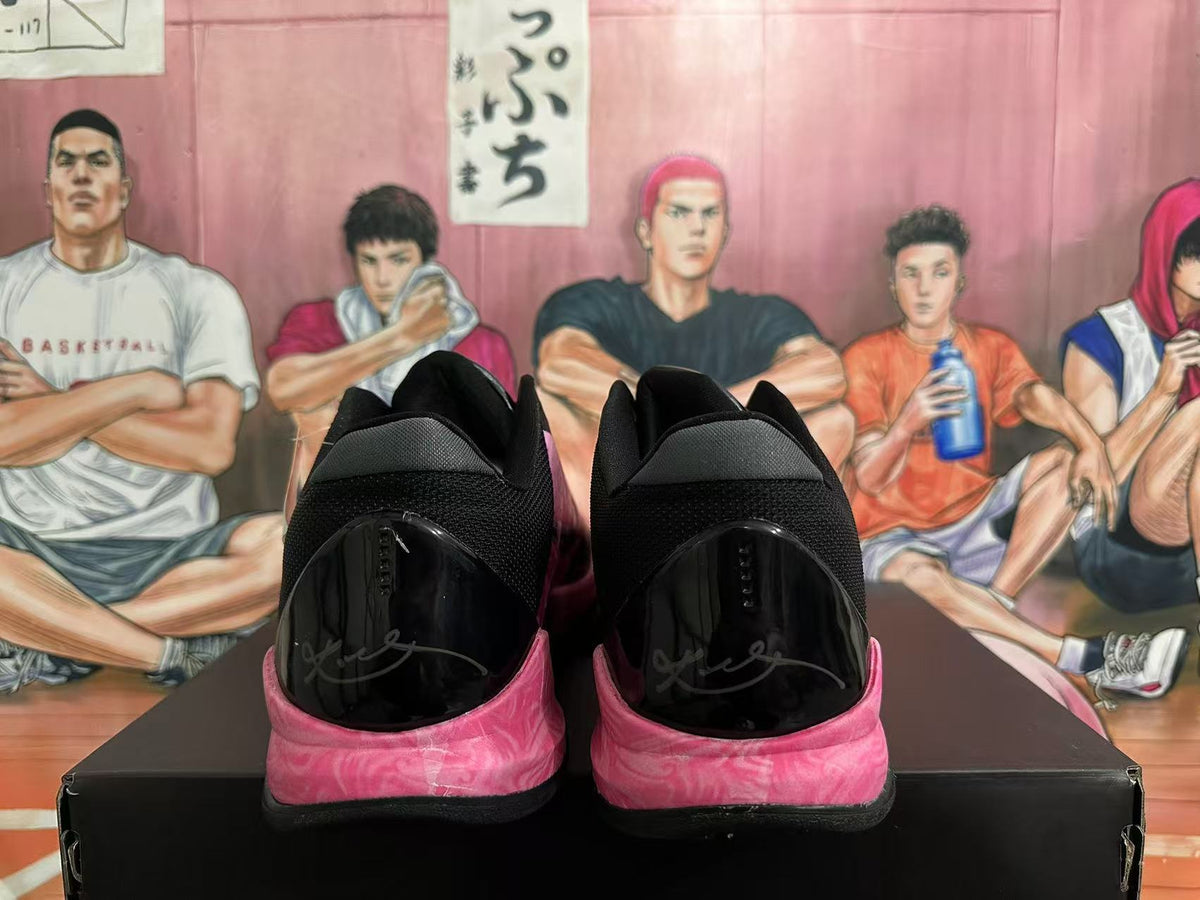 Rear view of black basketball shoes with pink marbled sole accents