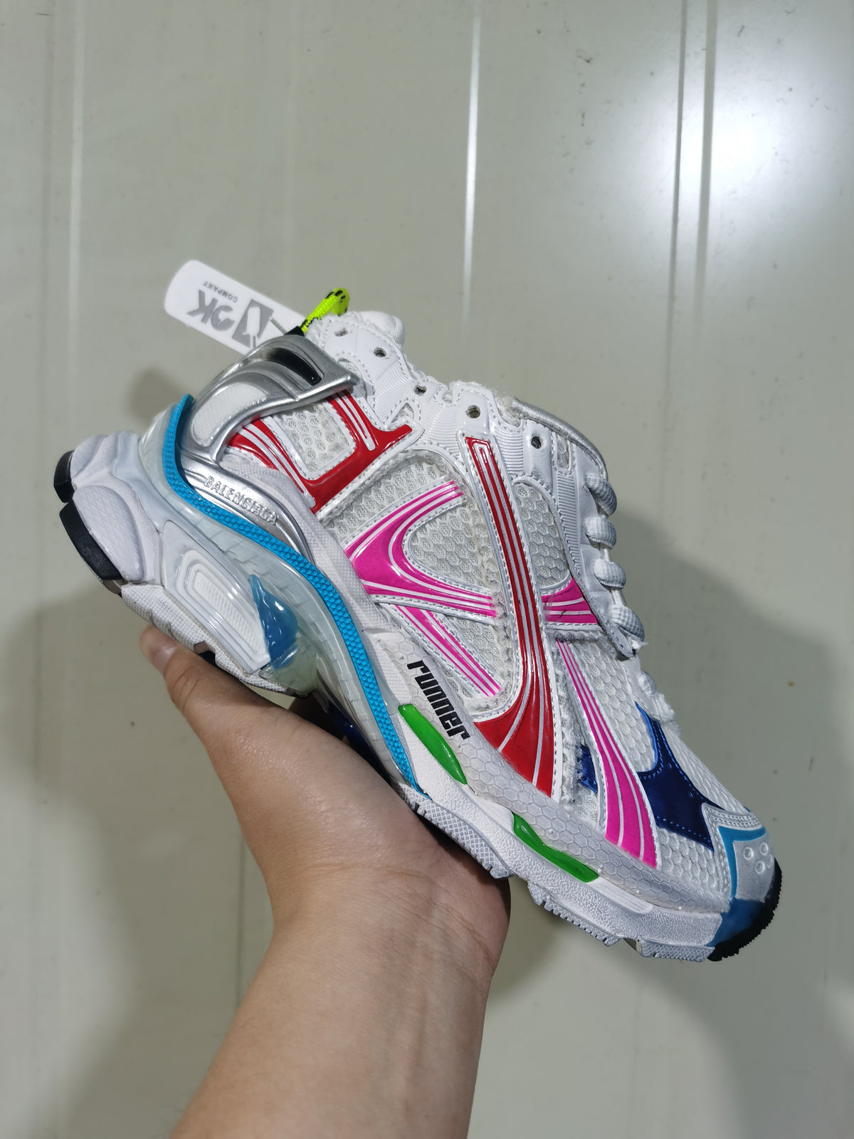 Angled view of the Puma Runner sneaker highlighting its metallic silver heel detail, layered colorful panels, mesh upper, and textured outsole.