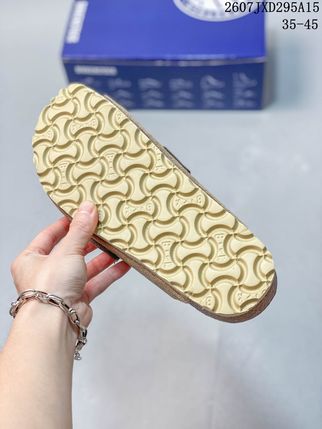 Close view of the sandal outsole showing a repeating curved tread pattern and a light-colored sole.