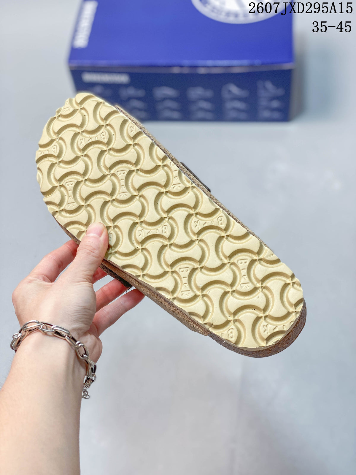 Close view of the sandal outsole showing a repeating curved tread pattern and a light-colored sole.