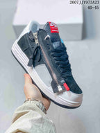 Angled side view highlighting the long metal zipper, red zipper pull, dark upper, white side panel, and white midsole.