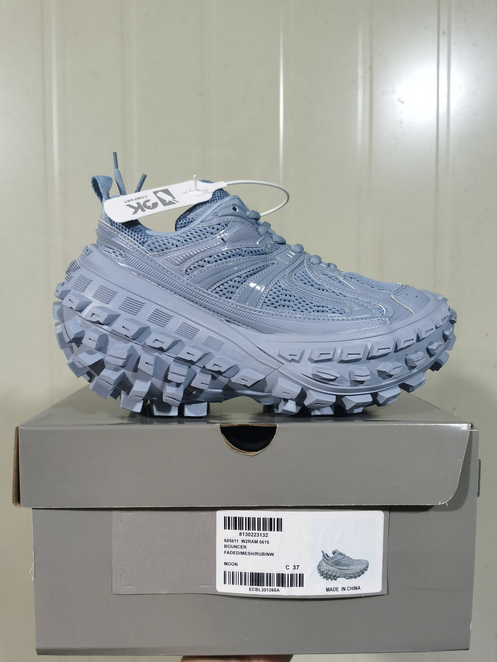 Moon-gray sneaker displayed on its box, with the box label visible beneath the shoe.