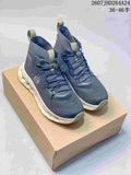 Pair of navy Loewe x On Cloudtilt High high-top sneakers displayed on a box, with olive accents and white sculpted soles.