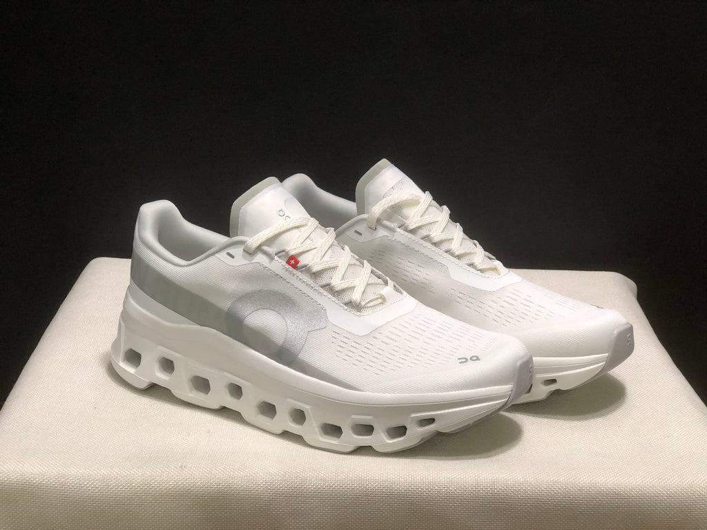 Front three-quarter view of the paired white Cloudmonster 1 sneakers.