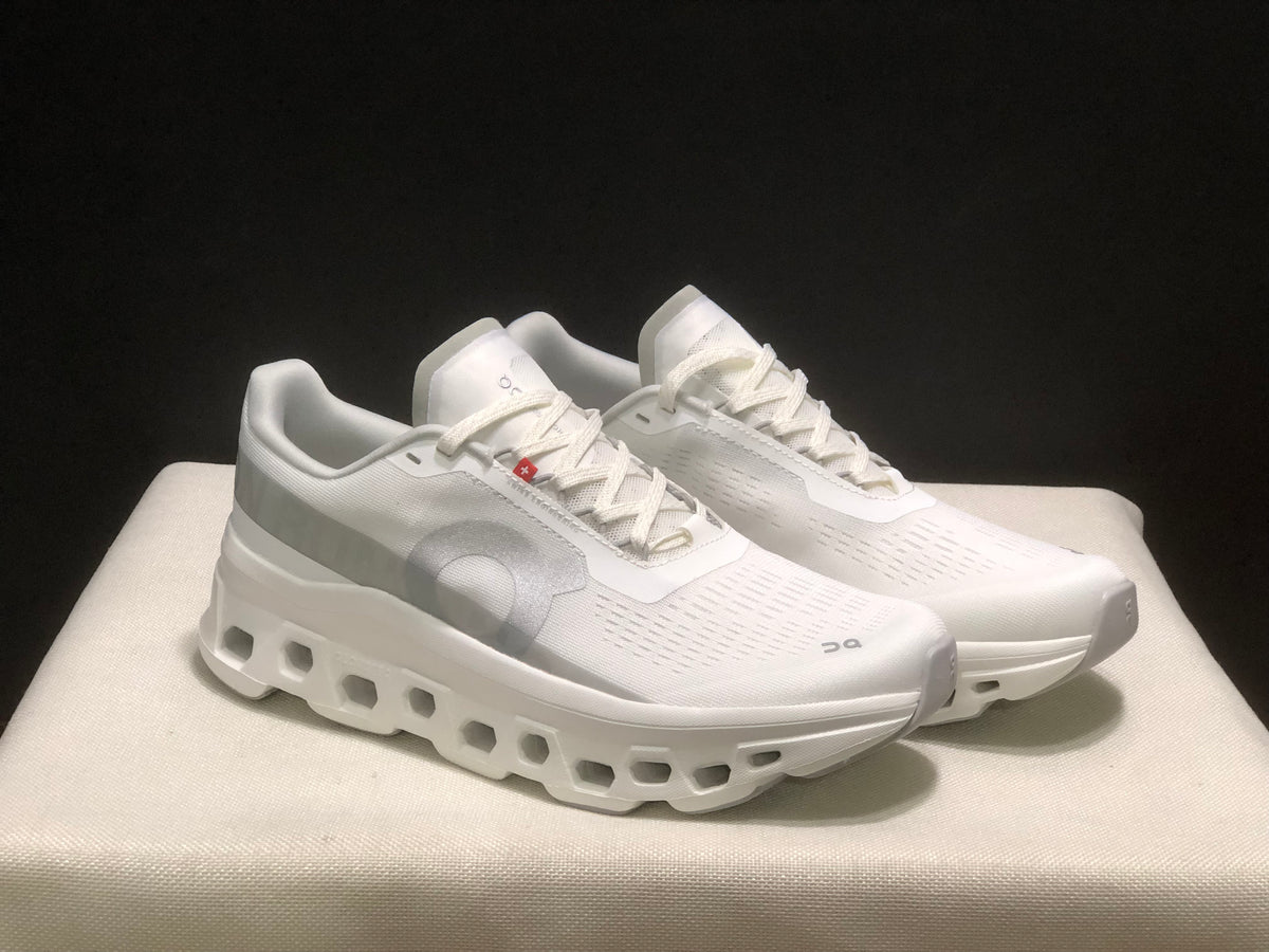 Front three-quarter view of the paired white Cloudmonster 1 sneakers.