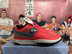 Side view of a red Nike basketball shoe with mesh panels, a dark swoosh, and a light midsole.