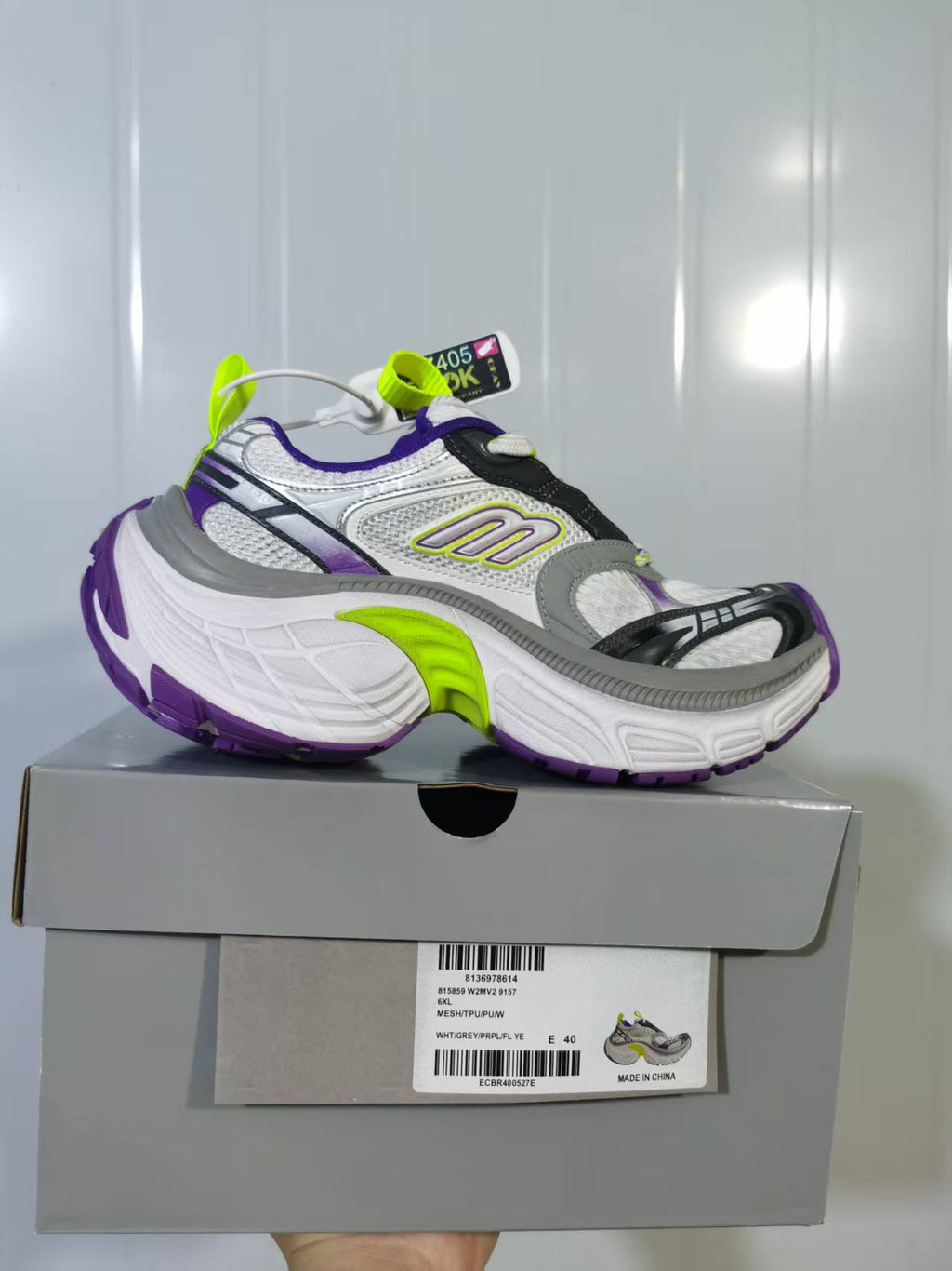 Skechers 9157 sneaker shown from the side above its box, with a white, grey, purple and lime color scheme; the box label shows size EU 40.