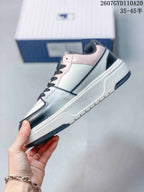 Side view of the low-top sneaker showing pink collar trim, contrasting overlays, and the raised sole.