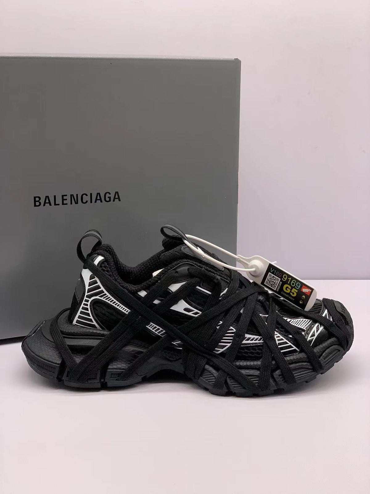 Black and white Balenciaga 3XL sneakers shown from the side with a branded box behind them.