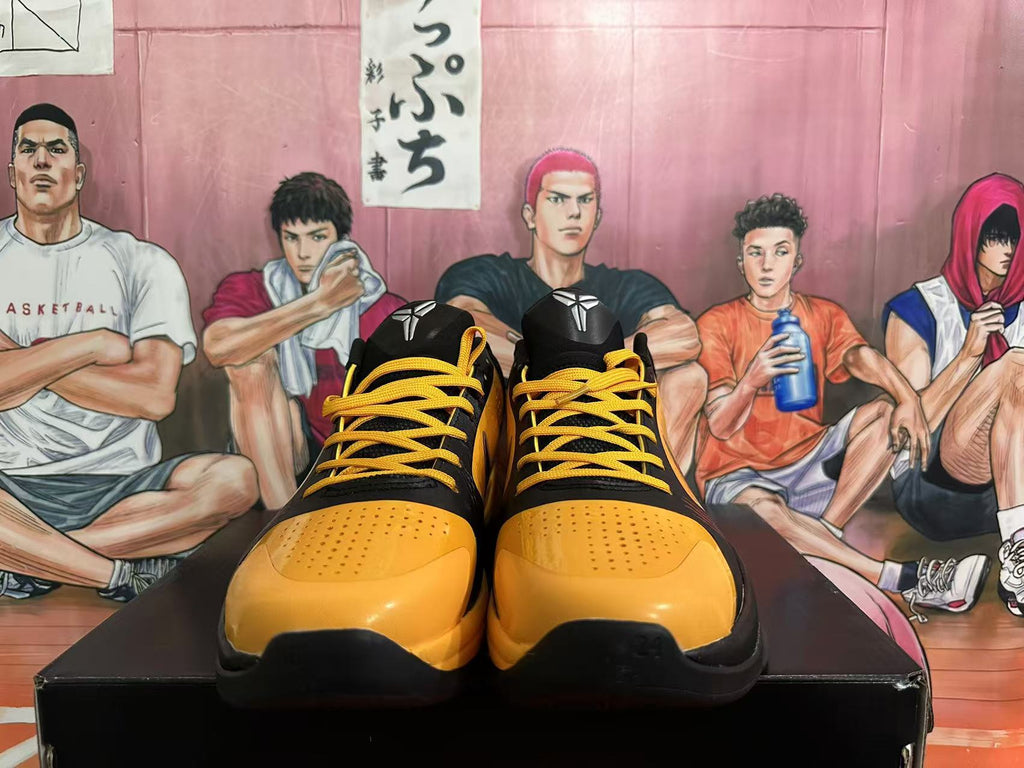 Front view showing yellow perforated toe panels and yellow laces on black Nike basketball shoes