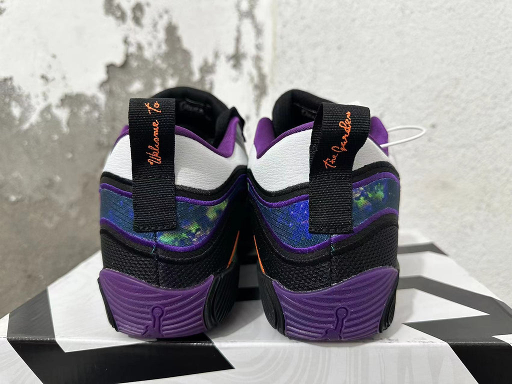 Rear view of black and purple Jordan basketball shoes with patterned heel panels and white heel details.