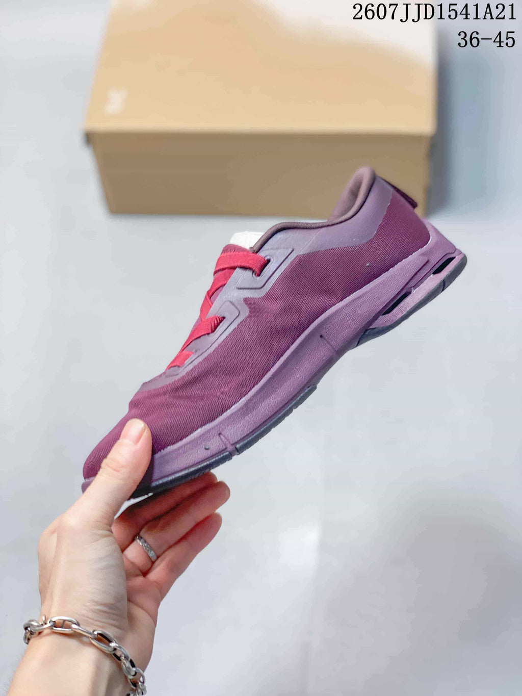 Side view of the purple and red sneaker showing the raised midsole profile and outsole construction.