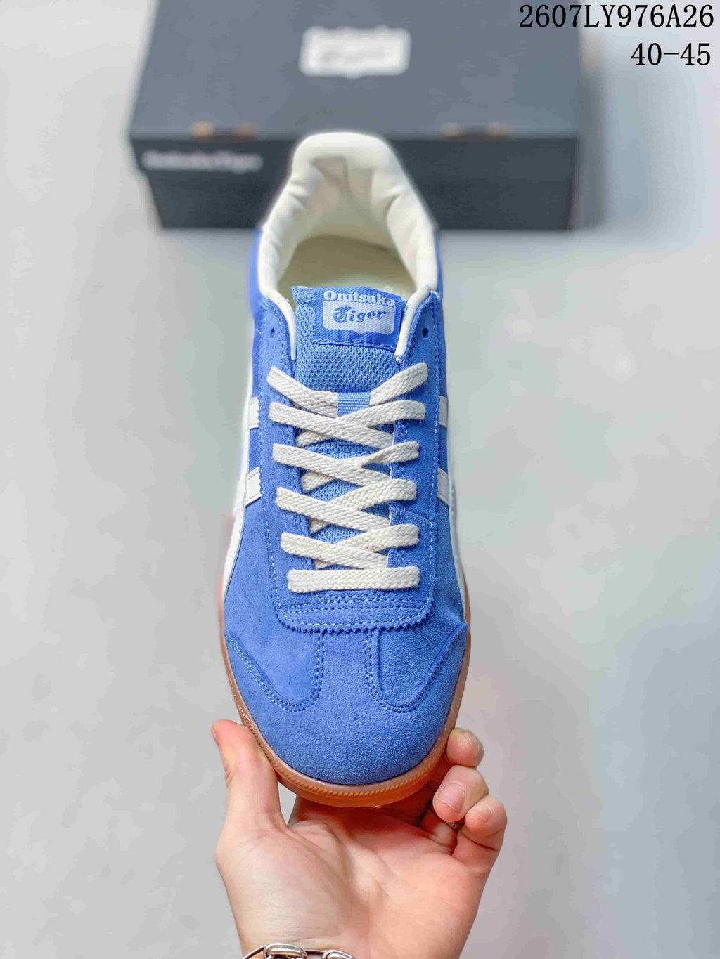 Top view of the blue sneaker showing white laces, a branded tongue label, and stitched toe detailing.