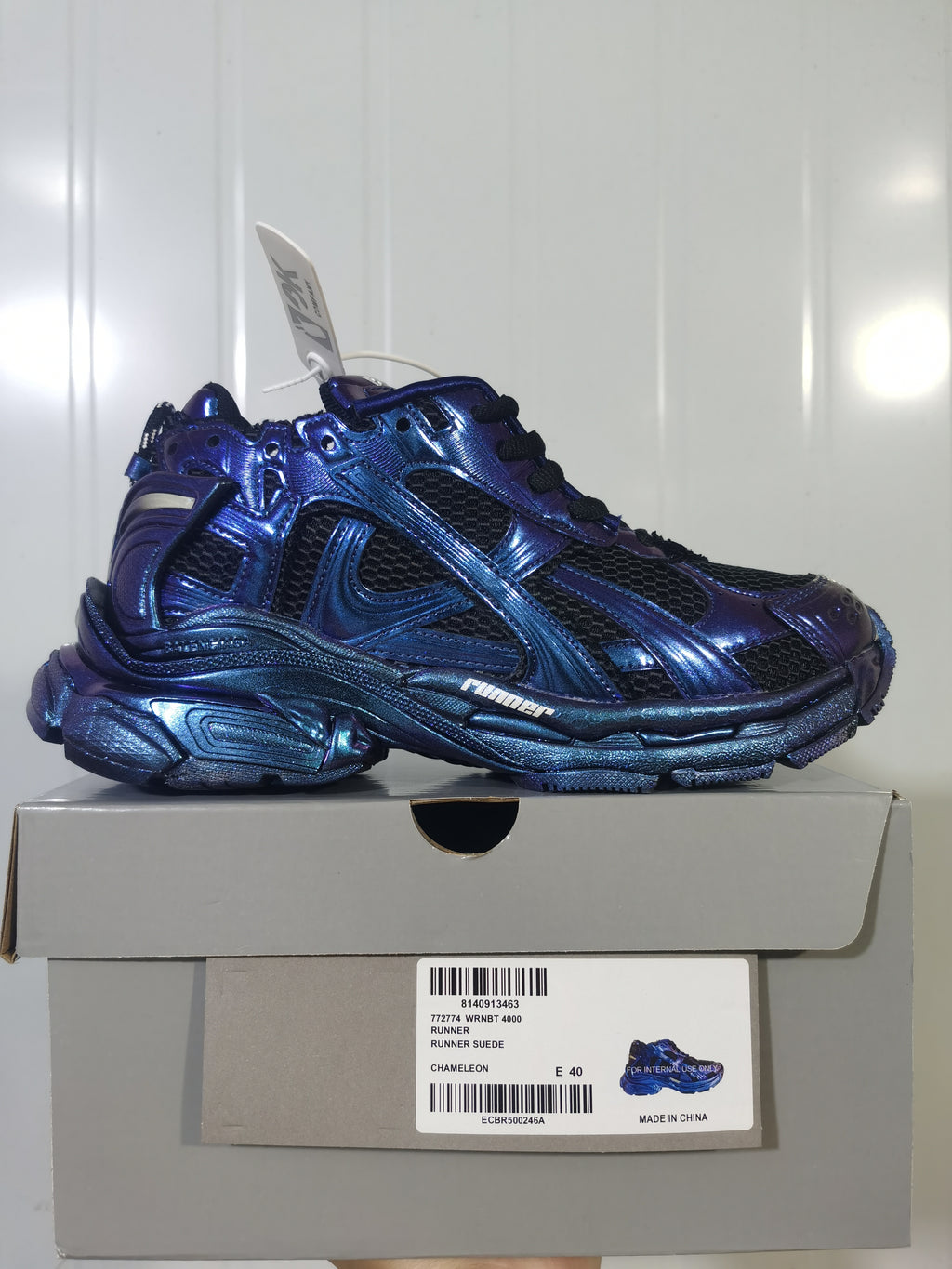 Side view of the metallic blue and purple Nike Runner 4000 sneaker displayed on its box, with the box label visible.