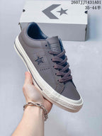 Close-up of a gray Converse One Star sneaker showing the star side detail and laces