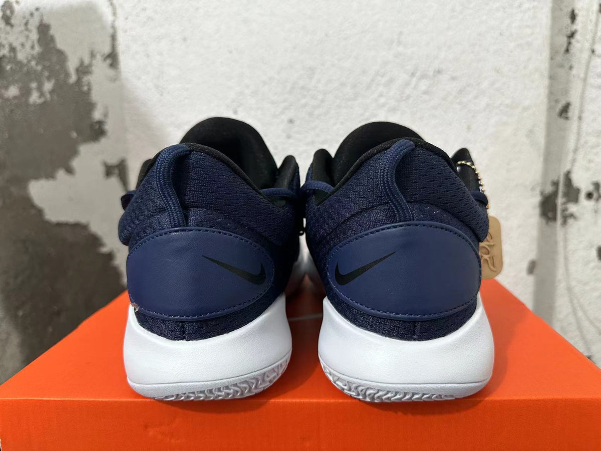 Rear view of navy blue Nike basketball shoes with white midsoles