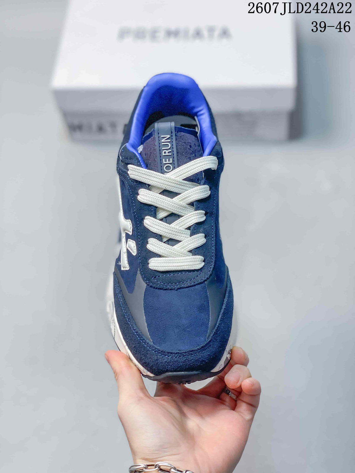 Top view of the navy blue trainer showing the rounded toe, layered upper and white laces.