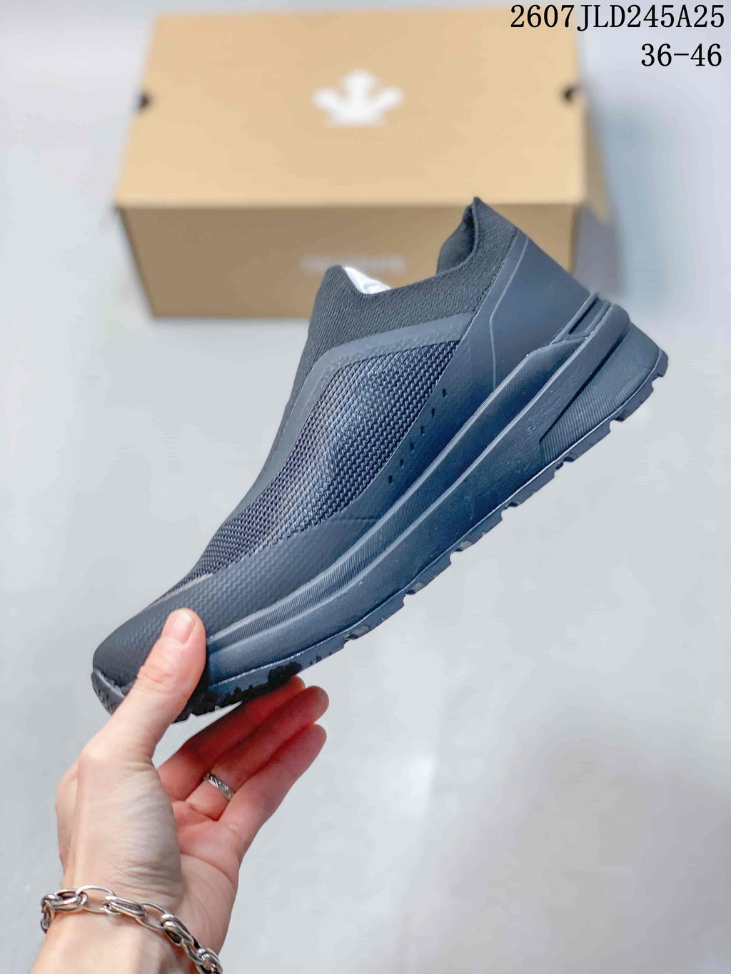 Side profile of the DESCENTE slip-on sneaker showing the textured upper, layered panels, and low-profile sole; image text shows style code 2607JLD245A25 and size range 36–46.