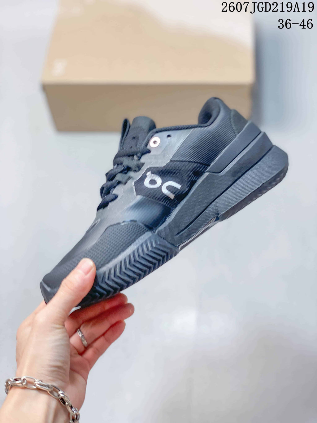 Side view of the black On THE ROGER Pro 2 tennis shoe showing its layered upper and midsole.