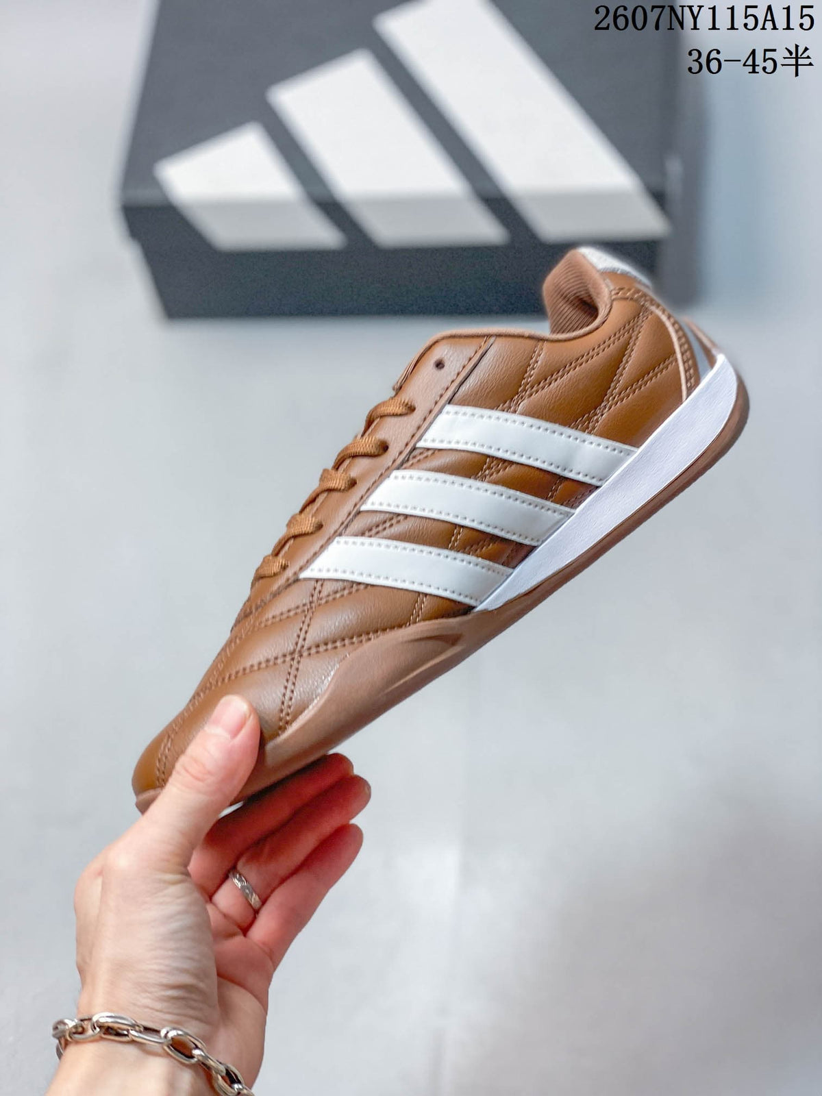 Side view highlighting the brown upper, white three-stripe panels, and white midsole.