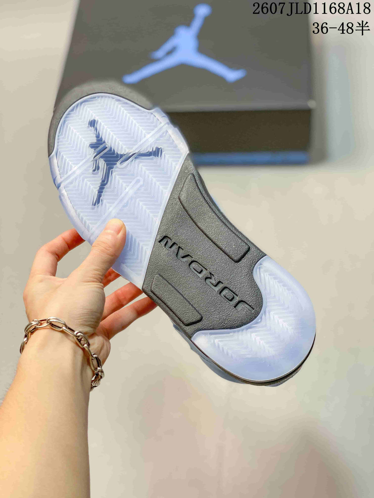 Translucent outsole viewed from below, showing a herringbone-style traction pattern and dark central section.