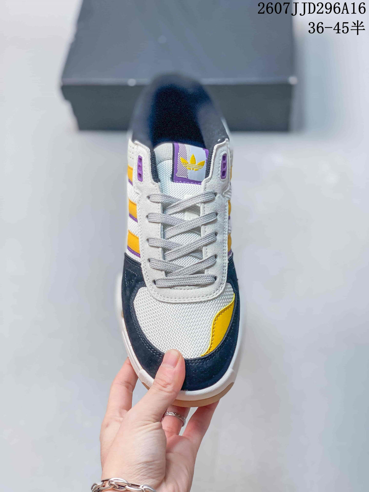 Top view of the lace-up sneaker showing the white mesh toe area, navy overlays, yellow accent and purple tongue details.