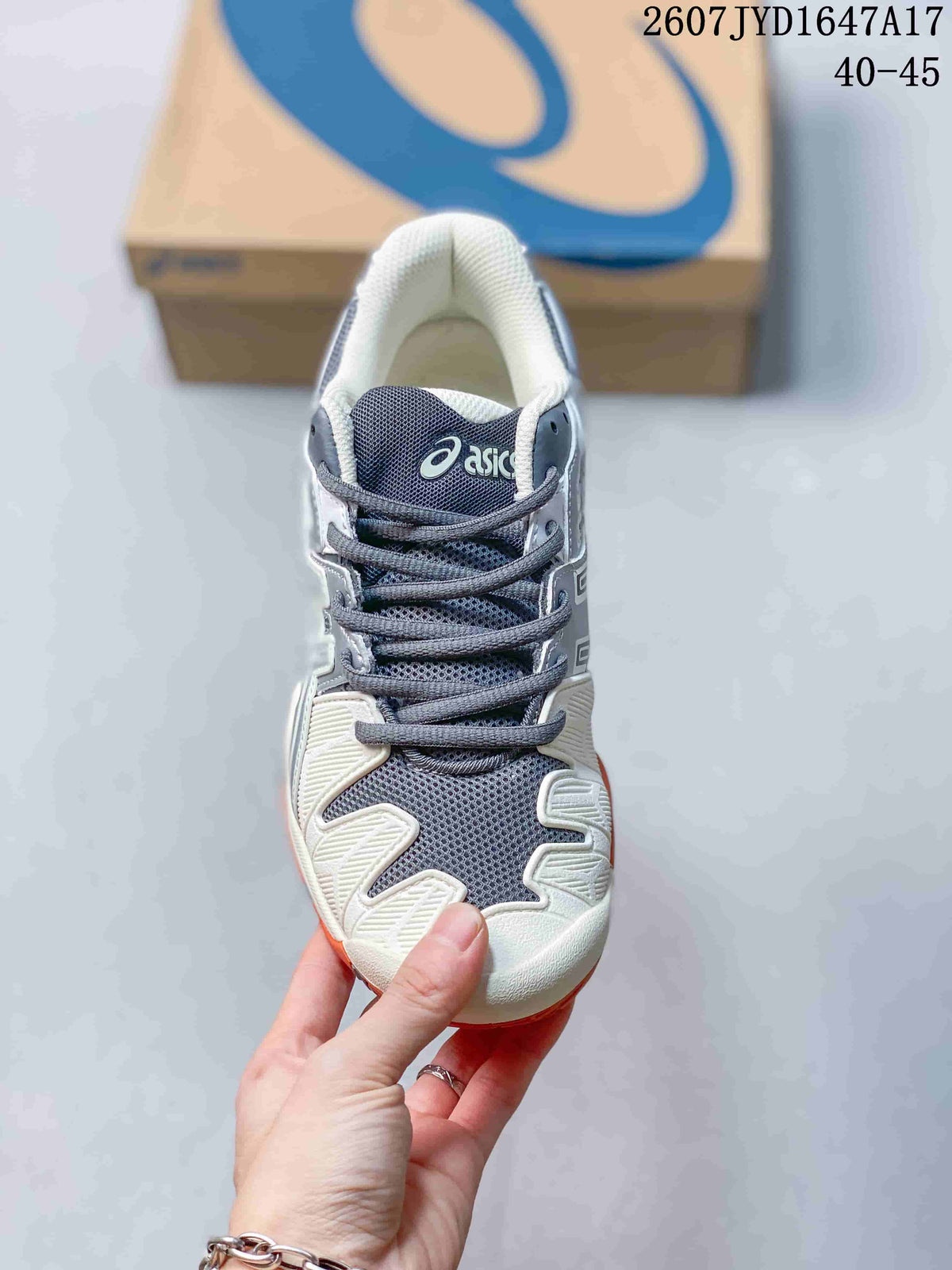 Top view of the lace-up ASICS tennis shoe showing the grey mesh tongue, white toe area and branded details; style code 2607JYD1647A17 and size range 40–45 are visible.