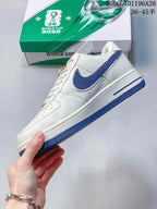 Side view of a white low-top sneaker with a blue side panel and blue outsole.