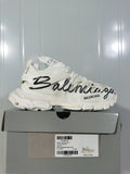 White Balenciaga Track sneaker with black graffiti-style lettering, shown on its box; the box label displays size E 40.