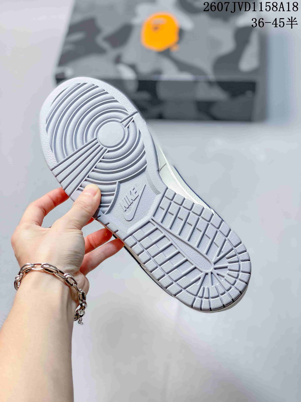 Bottom view of the sneaker showing the gray rubber outsole and circular traction pattern.