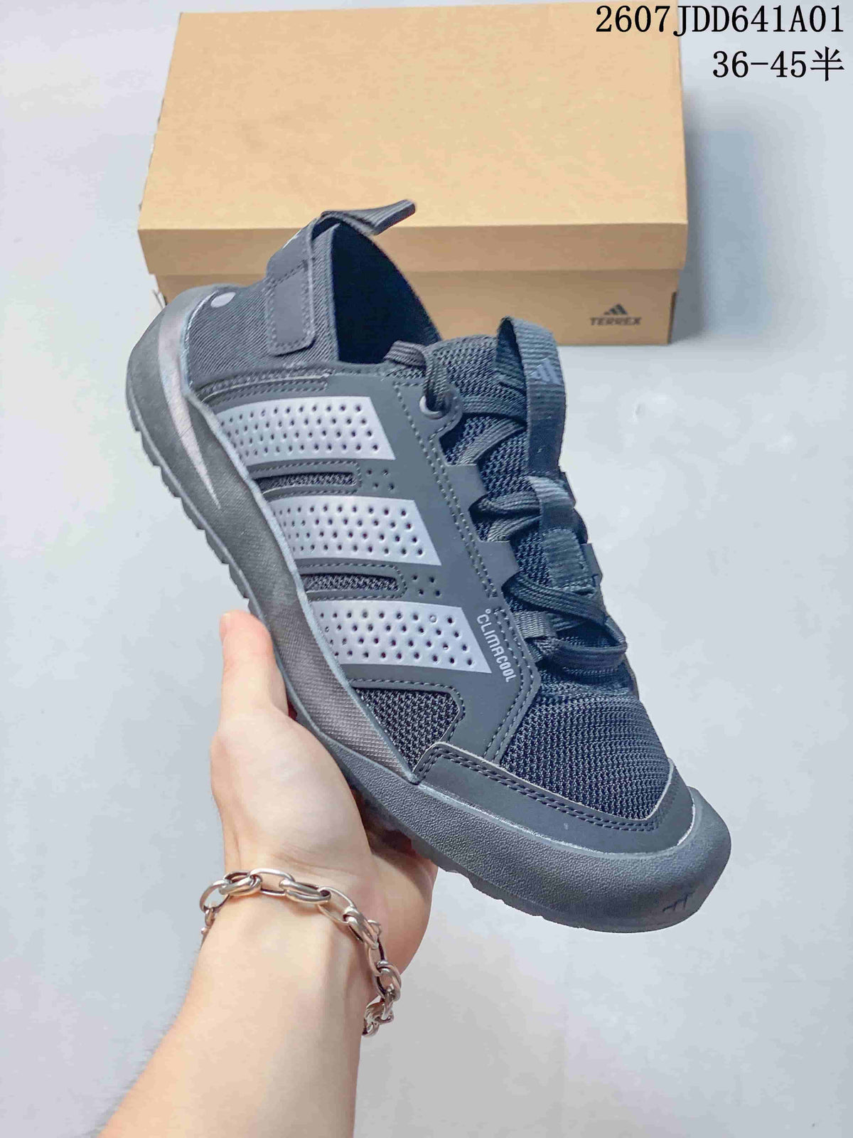 Angled side view of a gray sneaker with perforated overlays and a textured outsole.