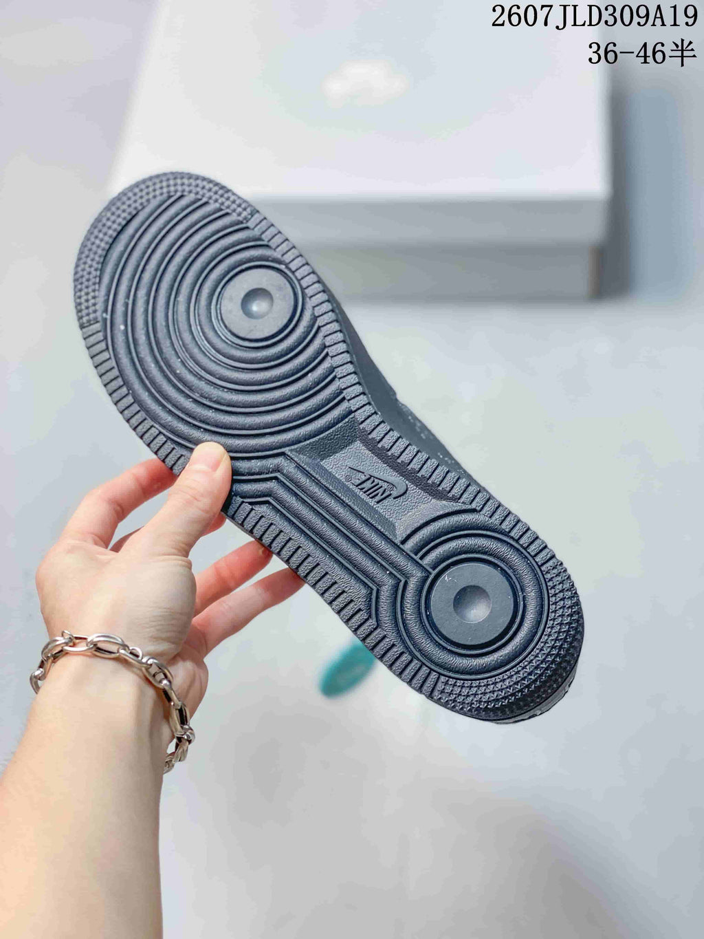 Close-up of the dark gray rubber outsole showing concentric circular traction zones and a textured perimeter.