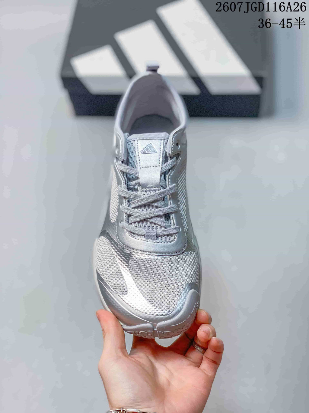 Top view of a silver gray lace-up sneaker with a textured toe and adidas tongue branding