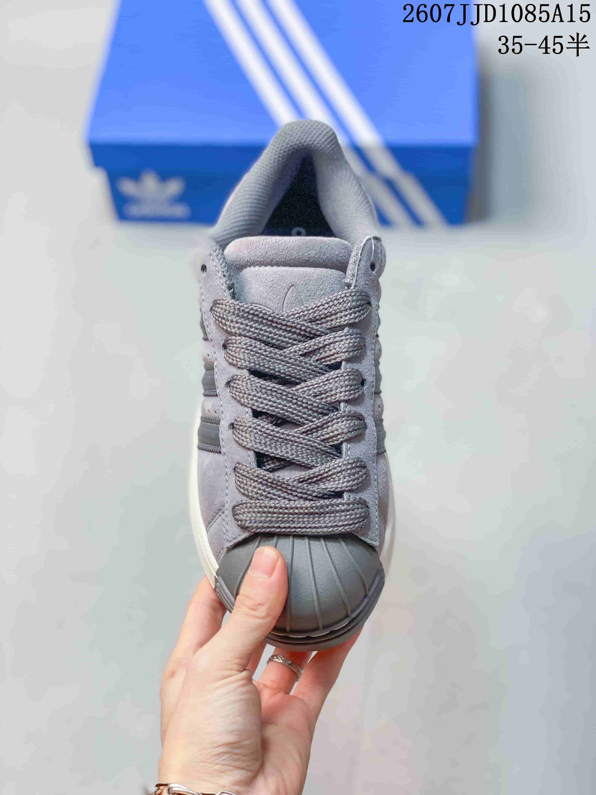 Front view of the grey sneaker showing the tonal laces, padded tongue, and ribbed shell toe.