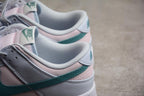 Close-up of the heel and collar showing white, pale pink and green panels with Nike branding.