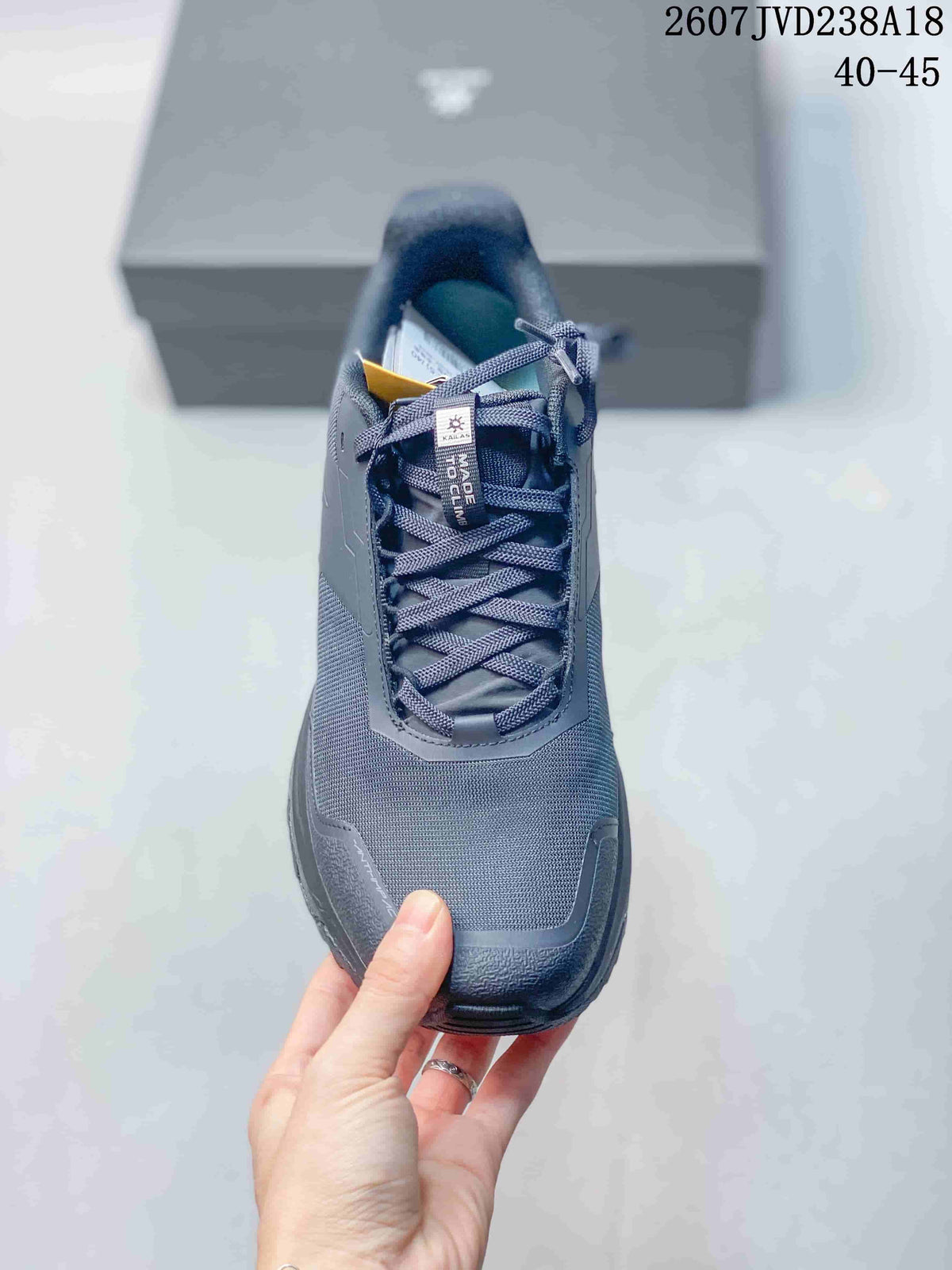 Top view of one dark gray hiking shoe showing the lace system, padded collar, tongue label, and textured upper.