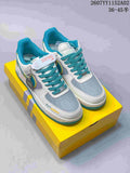 Pair of white, grey and turquoise low-top sneakers with yellow accents on a yellow box