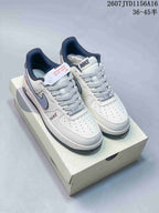 Pair of white, grey and black Nike low-top sneakers displayed on a shoebox, with the product code and size range shown above.